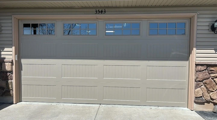 Beige garage door with windows by Barrett Overhead.