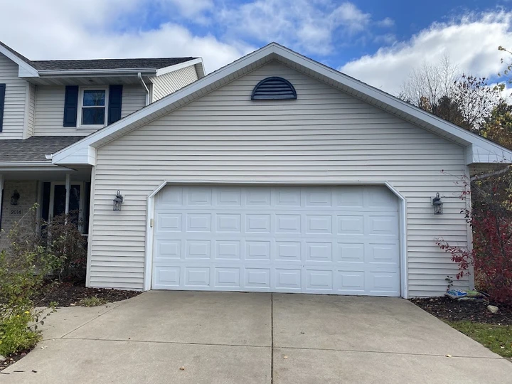 House with beige siding and a white garage door.
