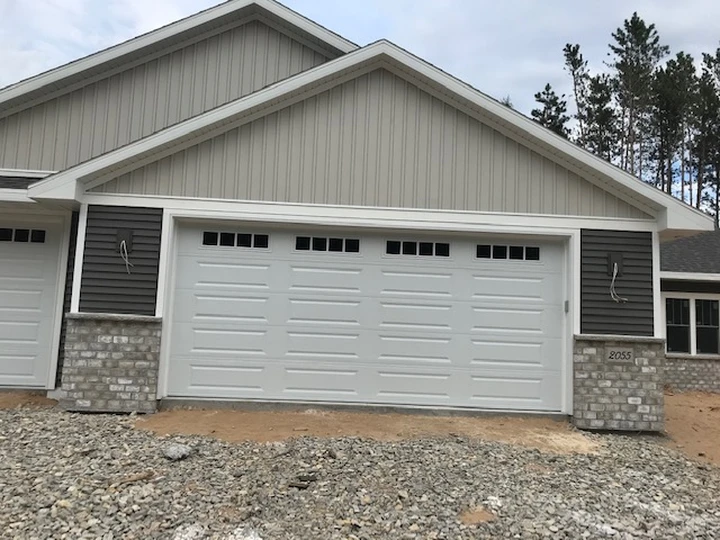 New residential garage with exterior brick and siding.