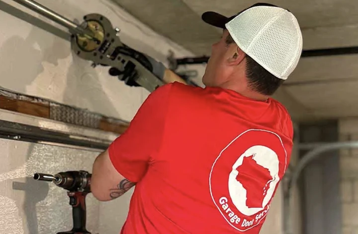 Technician repairing a garage door.