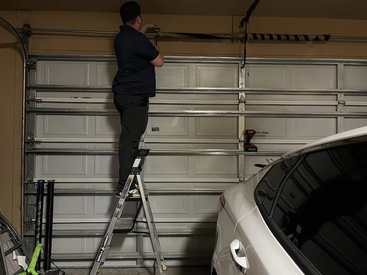 A technician repairing a garage door.