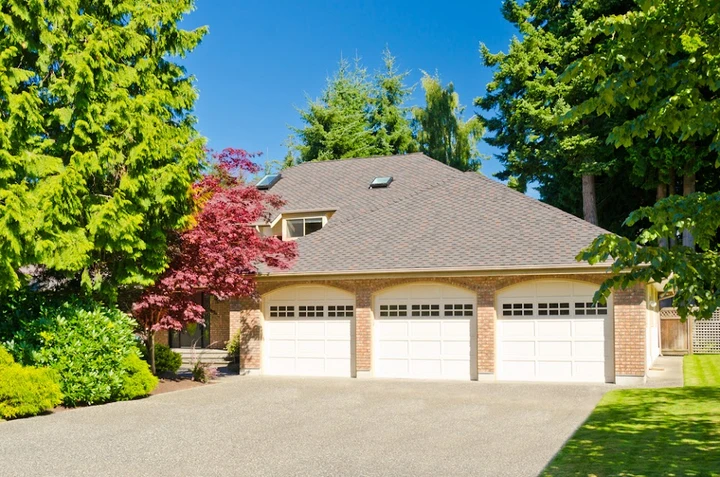 A three-car garage with white classic doors.