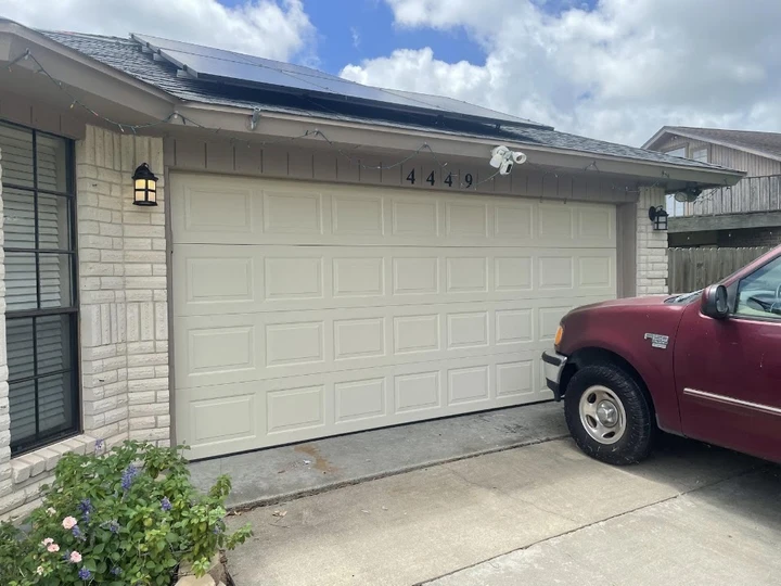 Beige garage door on a brick home.