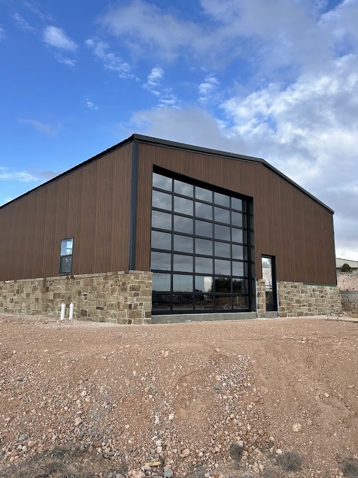 Brown metal building with large black glass door.