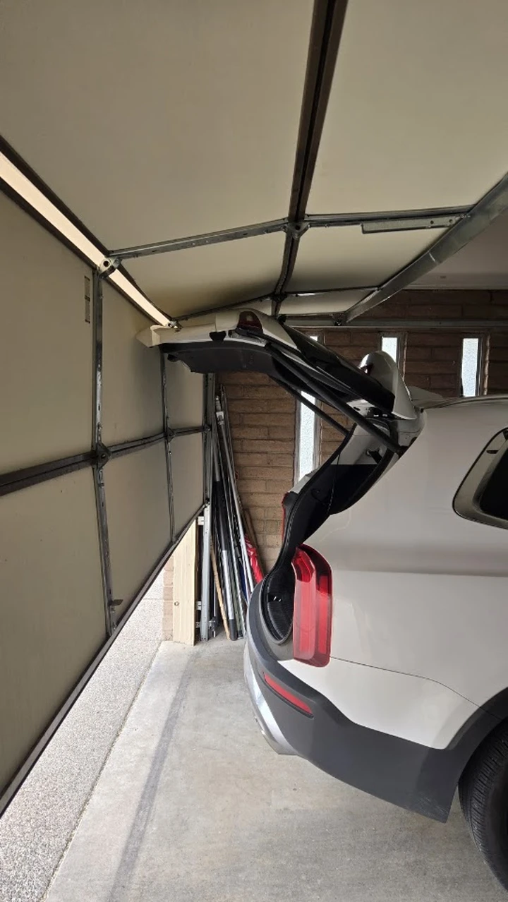Garage door and car collision damage.