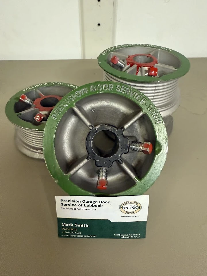 Garage door drums and a business card for Precision.