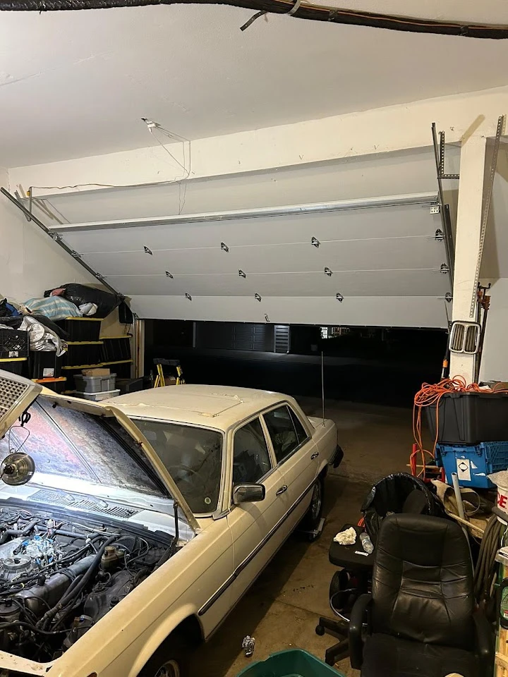 Garage door open inside a messy workshop.