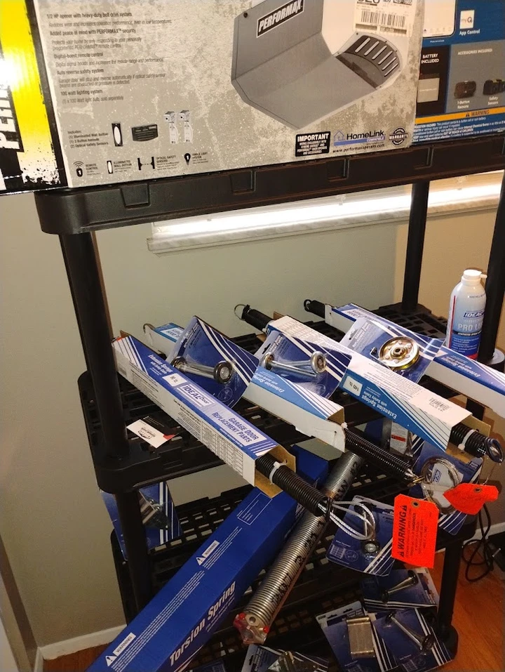 Garage door opener and parts on a storage shelf.