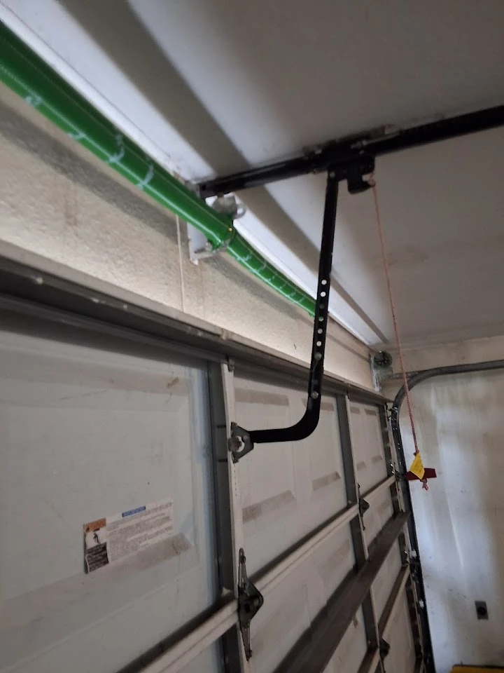 Garage door opener arm attached to the door.