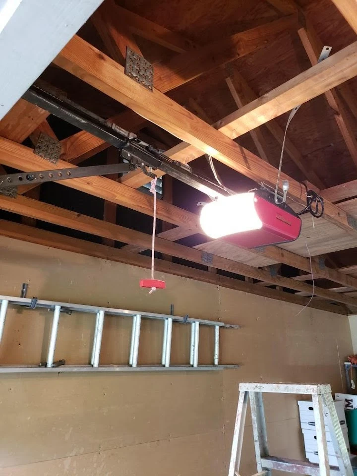 Garage door opener mounted on ceiling rafters.