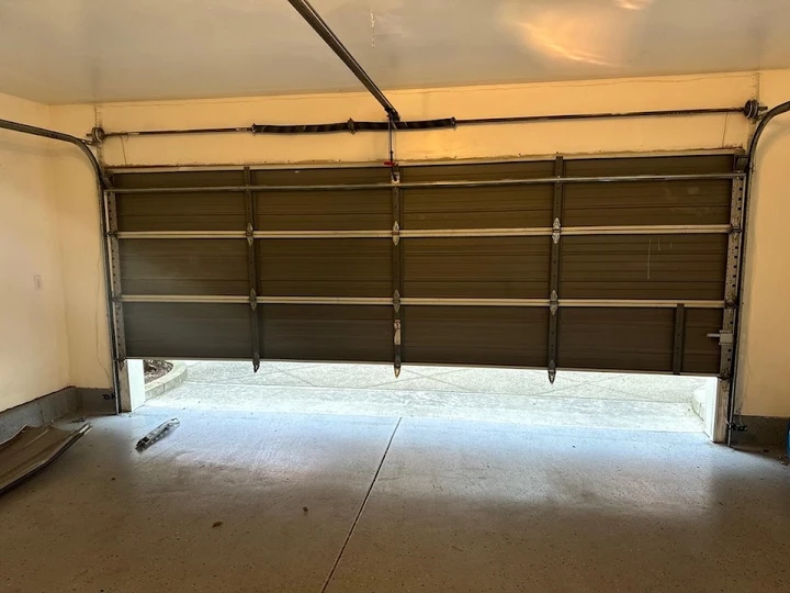 Garage door partially open in a residential garage.