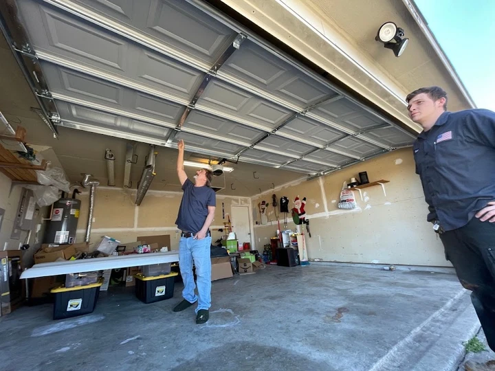 Garage door technicians inspecting a garage door.