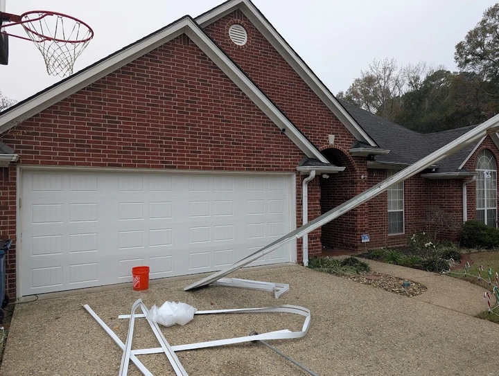 Garage door trim detached and lying on driveway.