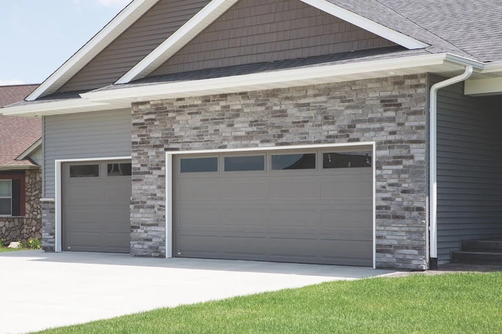 Gray garage doors on a stone-accented home.