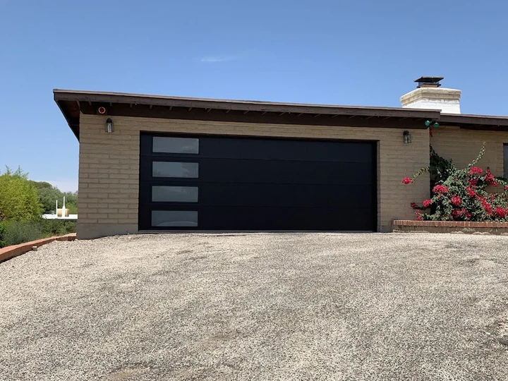 Modern black garage door with windows by Discount Door Service.