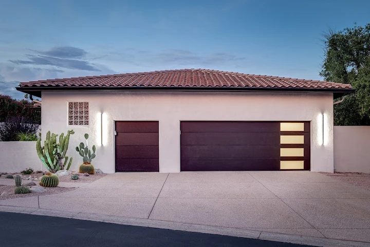 Modern garage doors with side windows and lighting.