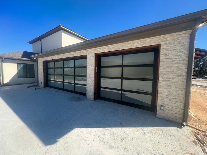 Modern glass garage doors with stone exterior.