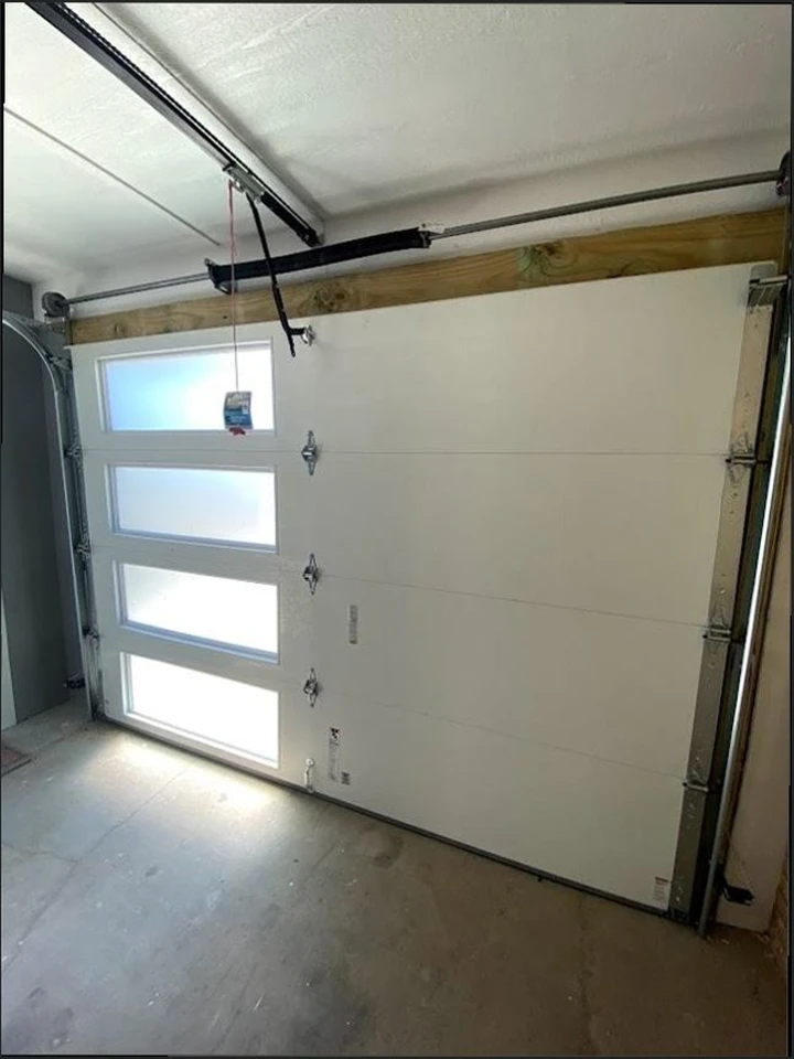 Modern white garage door with vertical glass windows.
