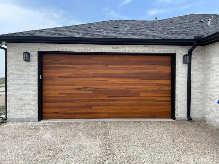 Modern wood-look garage door on a brick home.