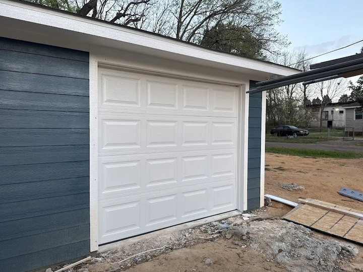 Newly installed white residential garage door.
