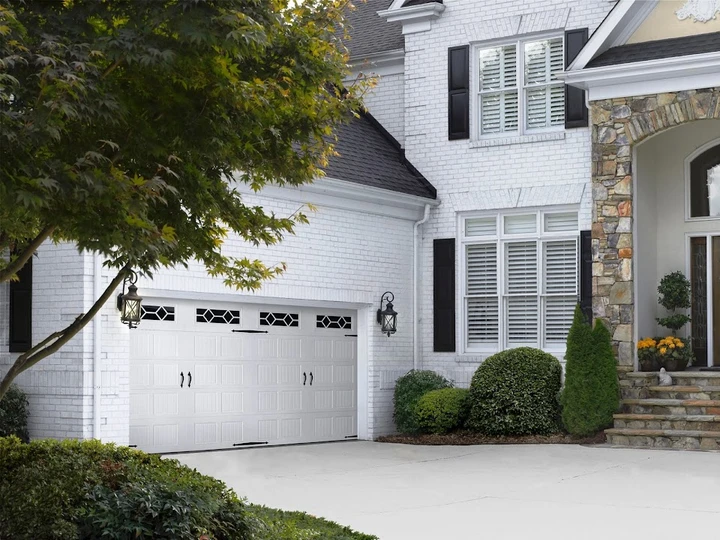 Renner Garage Door installed on a white brick home.