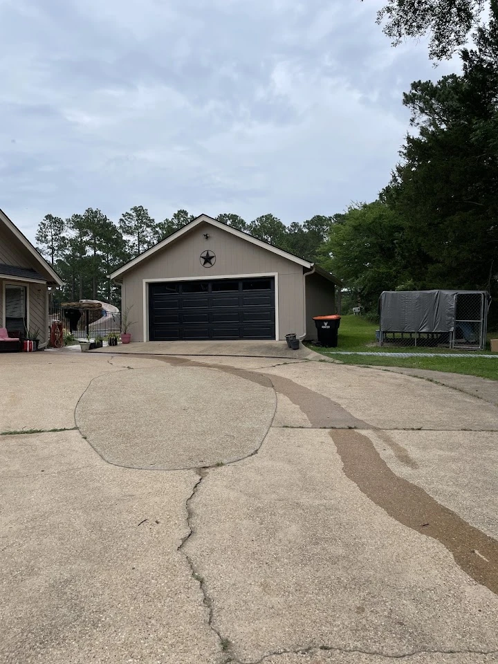 Residential garage with dark door and driveway.