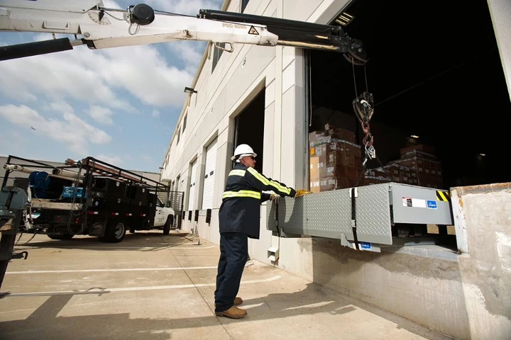 Technician installing a dock leveler.