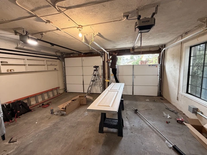 Technician installing a residential garage door.