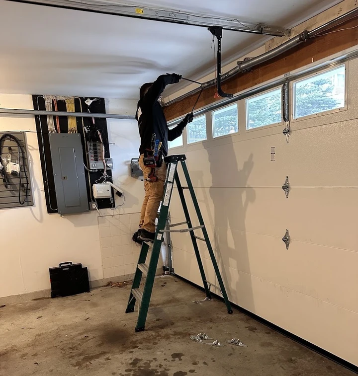 Technician repairing a residential garage door.