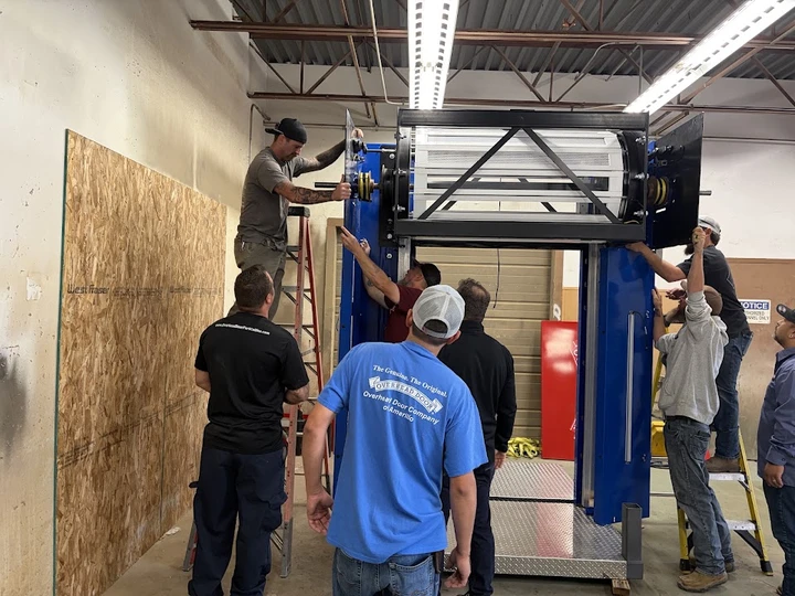 Technicians installing an overhead door system.