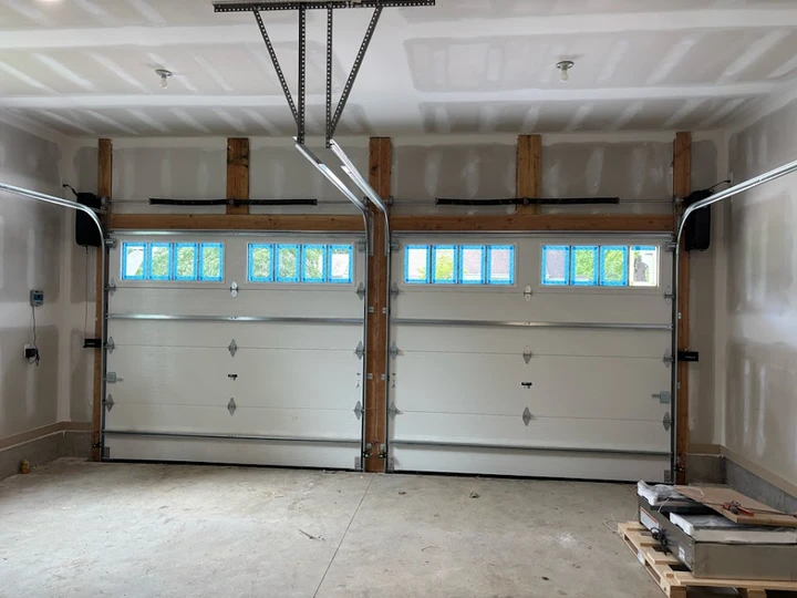 Two garage doors with blue window tape.