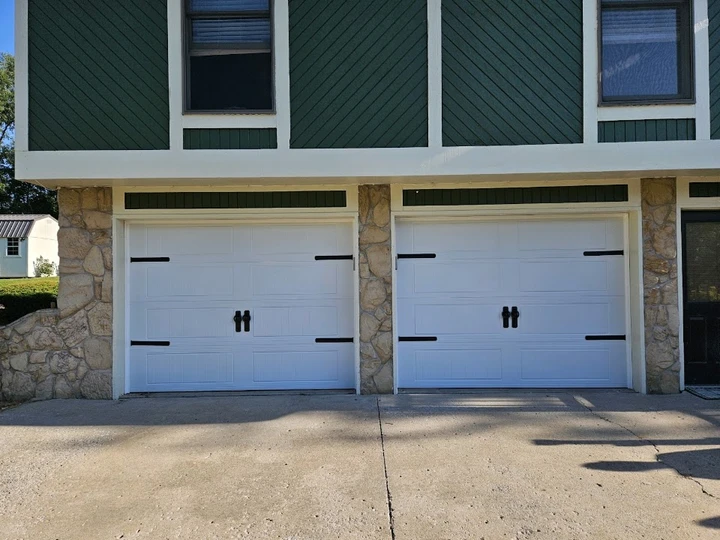 Two white garage doors with black hardware.