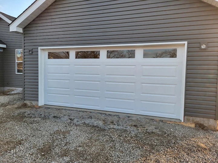 White garage door on a gray house by RS Garage Door.