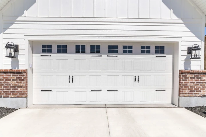 White garage door with windows and brick accents.