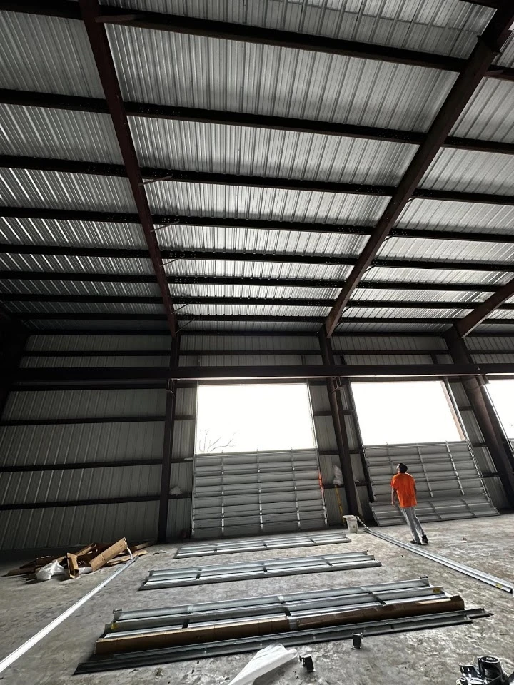 Worker installing overhead industrial doors.