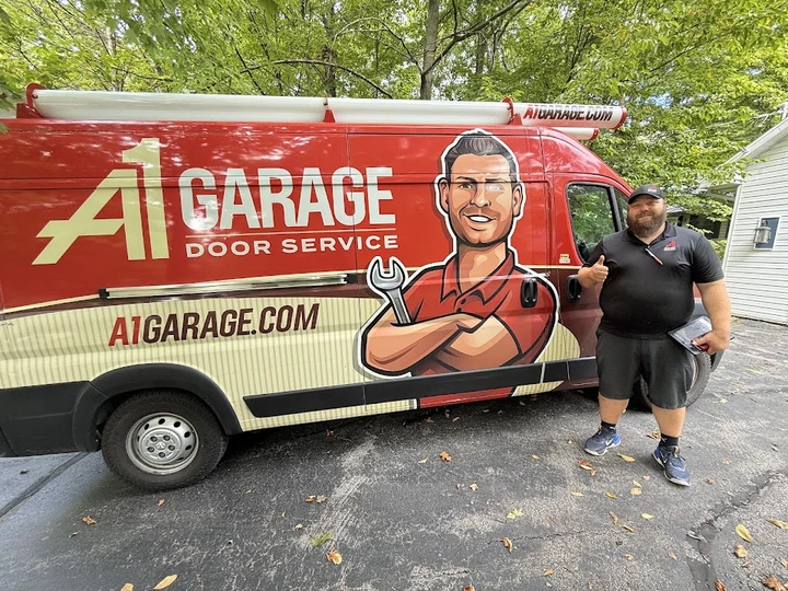 A technician stands next to an A1 Garage van.