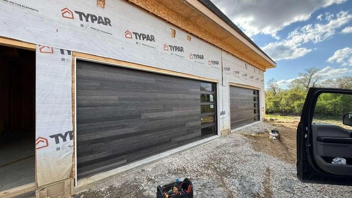 Modern gray wood-look garage doors installed.