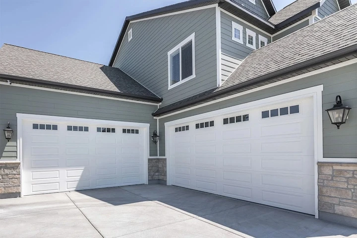 Modern white garage doors at a suburban home.