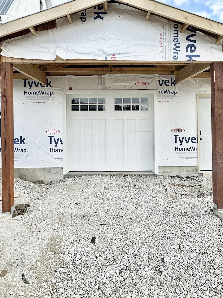 Newly installed white carriage-style garage door.