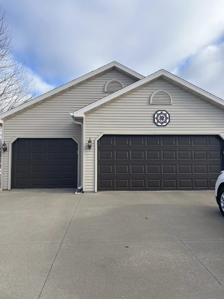 Tan house with two brown garage doors.
