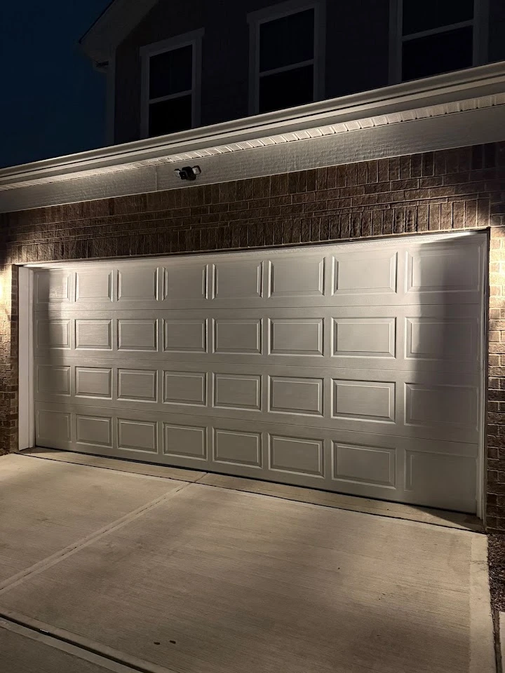 White garage door of a residential home at night.